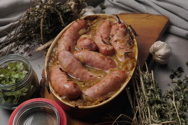 Bela klobasa, pečena v pivu z gorčico in čebulo